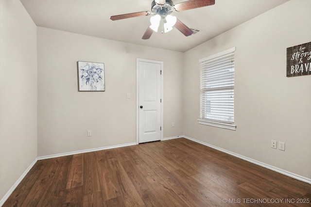 spare room with ceiling fan and dark hardwood / wood-style flooring