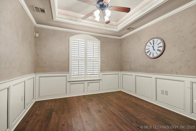 unfurnished room with a raised ceiling, crown molding, dark hardwood / wood-style flooring, and ceiling fan