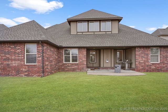 rear view of property featuring a lawn and a patio