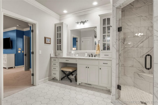 bathroom with vanity, a shower with shower door, and ornamental molding