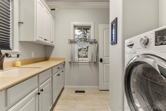 laundry area featuring cabinets, crown molding, washer / dryer, and sink