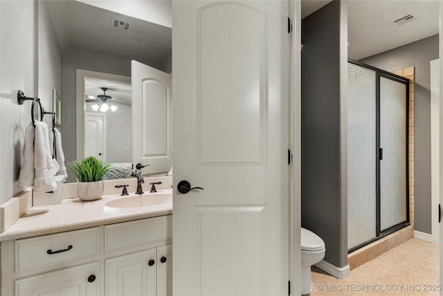 bathroom with tile patterned flooring, vanity, toilet, and walk in shower