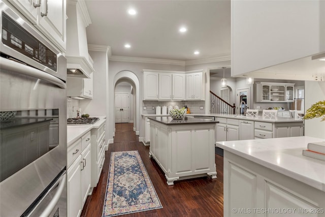 kitchen with white cabinets, decorative backsplash, dark hardwood / wood-style flooring, and ornamental molding