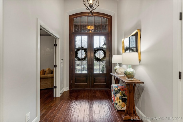 foyer entrance featuring french doors, a chandelier, and dark hardwood / wood-style floors