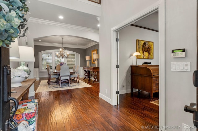 entrance foyer with a chandelier, dark hardwood / wood-style flooring, and ornamental molding