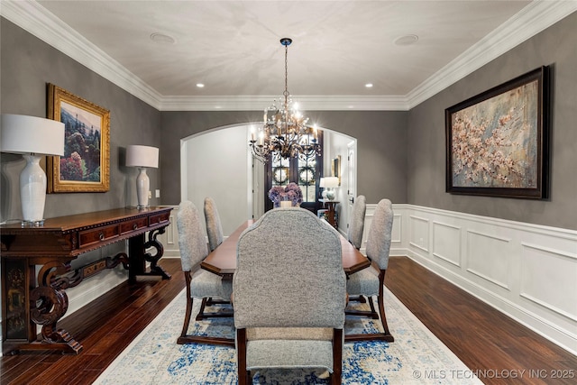 dining room with dark hardwood / wood-style flooring, an inviting chandelier, and ornamental molding