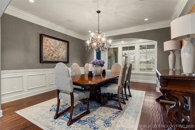 dining area featuring dark hardwood / wood-style flooring, crown molding, and a chandelier