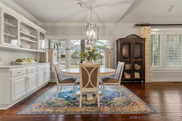 dining area featuring crown molding, dark wood-type flooring, and a notable chandelier