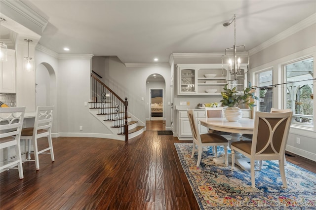 dining room featuring dark wood-type flooring, a notable chandelier, and ornamental molding