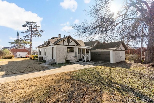 view of front of house with a garage, central air condition unit, and a front lawn