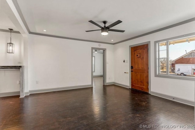 interior space with ceiling fan, dark hardwood / wood-style floors, and ornamental molding