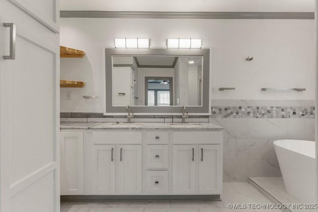 bathroom with a bathtub, vanity, and tile walls