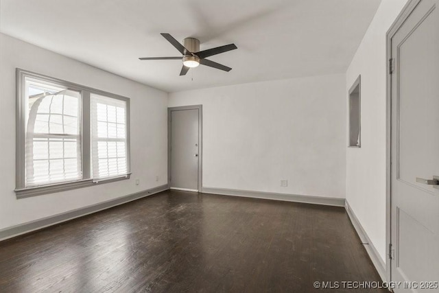 empty room with dark hardwood / wood-style flooring and ceiling fan