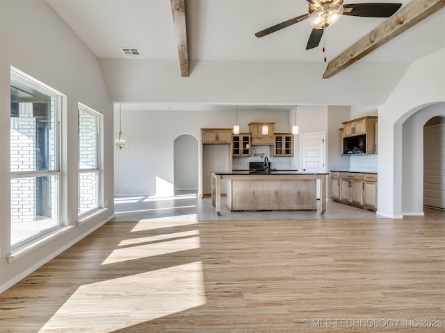 kitchen featuring pendant lighting, backsplash, ceiling fan with notable chandelier, sink, and light hardwood / wood-style floors