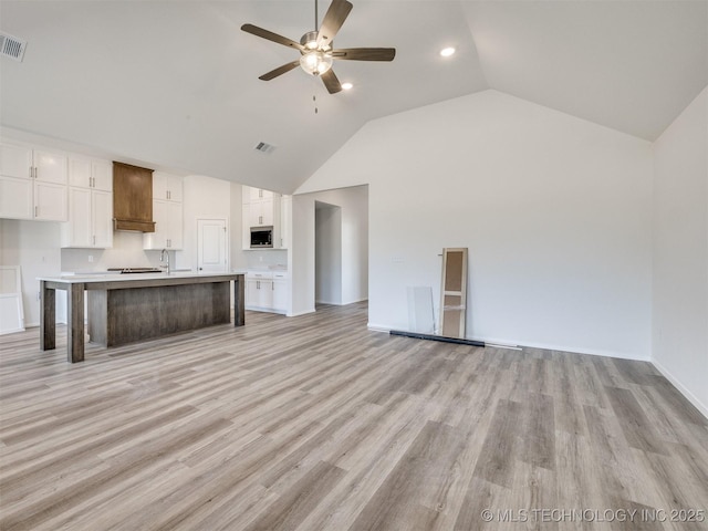 unfurnished living room featuring visible vents, recessed lighting, light wood-style floors, a ceiling fan, and high vaulted ceiling