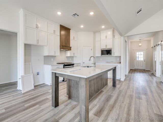 kitchen with light wood-style floors, stainless steel appliances, visible vents, and a sink