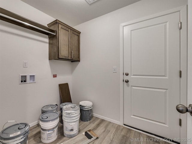 washroom featuring light wood-type flooring, baseboards, cabinet space, and hookup for a washing machine