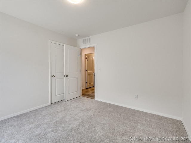 unfurnished bedroom featuring carpet, visible vents, and baseboards