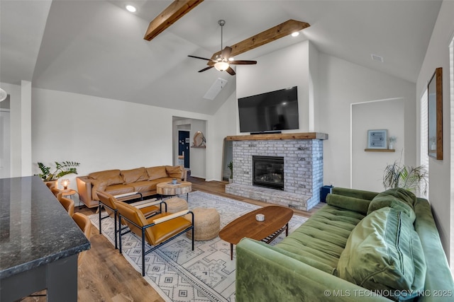 living room with a fireplace, hardwood / wood-style floors, lofted ceiling with beams, and ceiling fan