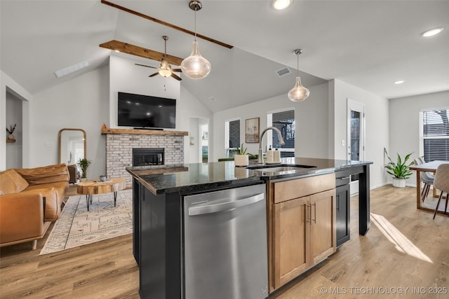 kitchen featuring dishwasher, a center island with sink, sink, vaulted ceiling with beams, and light wood-type flooring