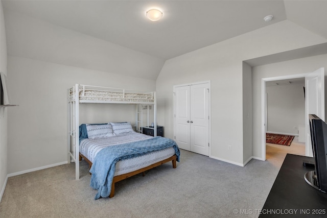 bedroom featuring a closet, light colored carpet, and vaulted ceiling