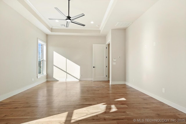 unfurnished living room featuring a tray ceiling, ceiling fan, and hardwood / wood-style floors