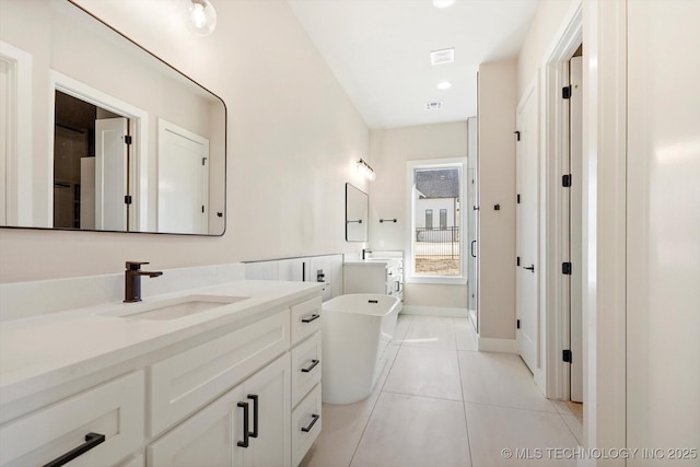 bathroom featuring tile patterned flooring, a washtub, and vanity