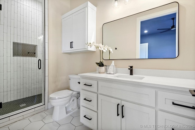 bathroom with ceiling fan, tile patterned floors, toilet, vanity, and a shower with shower door