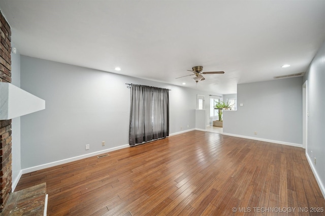 unfurnished living room featuring hardwood / wood-style floors, a fireplace, and ceiling fan