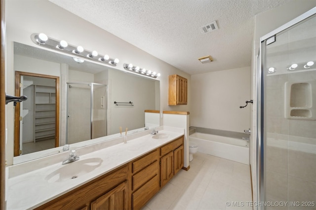 1504 N 26th St, Broken Arrow, OK 74014 - bathroom with a shower stall, a bath, double vanity, a textured ceiling, and a spacious closet
