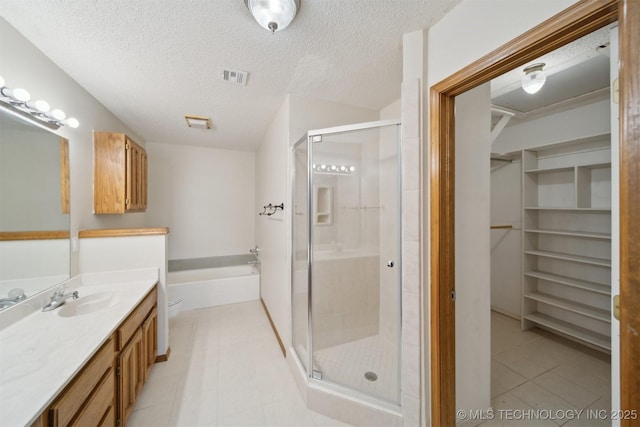 bathroom featuring vanity, a textured ceiling, and separate shower and tub