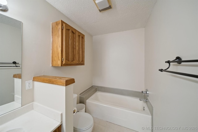 bathroom featuring a tub, tile patterned flooring, vanity, toilet, and a textured ceiling