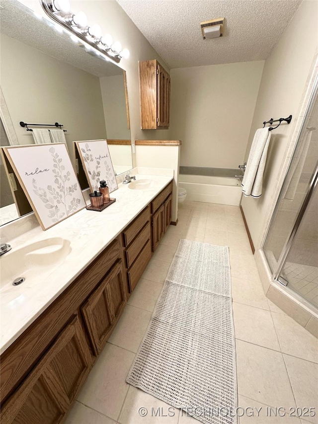 1504 N 26th St, Broken Arrow, OK 74014 - bathroom featuring double vanity, tile patterned flooring, a textured ceiling, a shower stall, and a garden tub