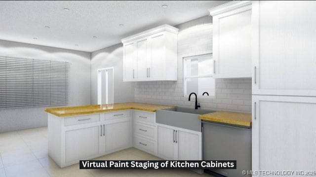 kitchen with white cabinetry, sink, backsplash, and kitchen peninsula