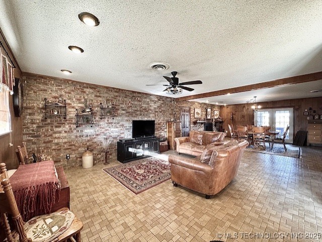 living room featuring brick wall, visible vents, and brick patterned floor