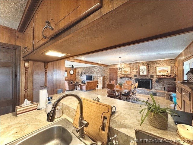 kitchen with open floor plan, light countertops, a sink, and a fireplace