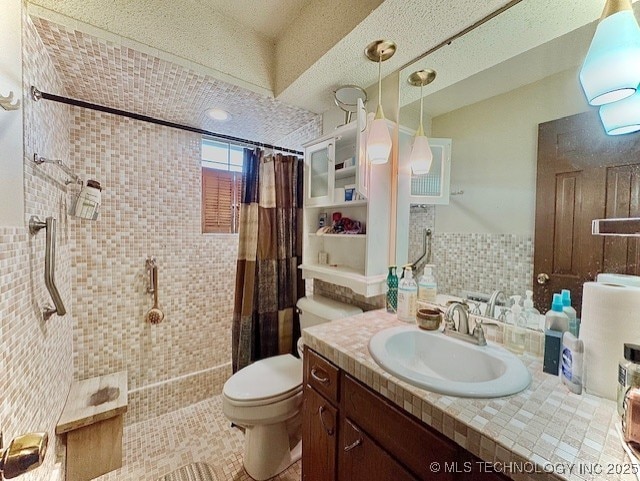 bathroom with tiled shower, vanity, and toilet