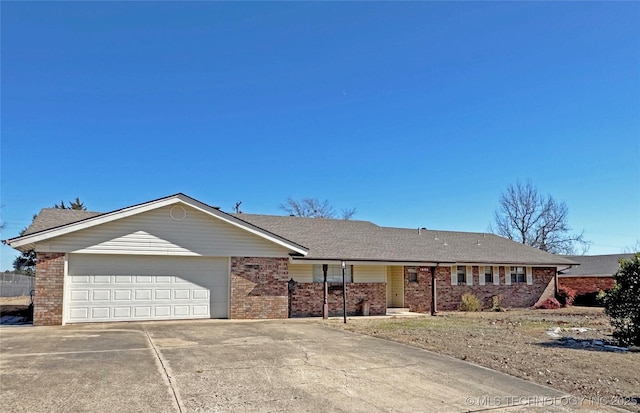 ranch-style house with a garage, driveway, brick siding, and roof with shingles