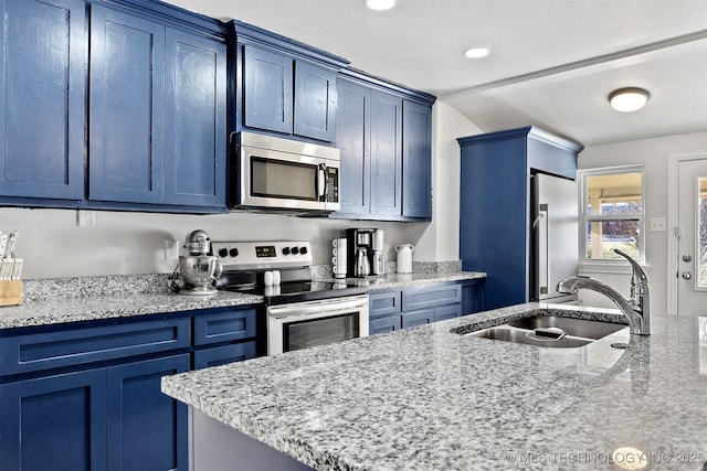 kitchen featuring blue cabinetry, sink, light stone countertops, and stainless steel appliances