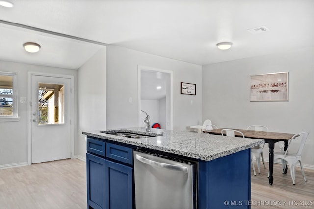 kitchen with stainless steel dishwasher, a center island with sink, blue cabinets, and sink