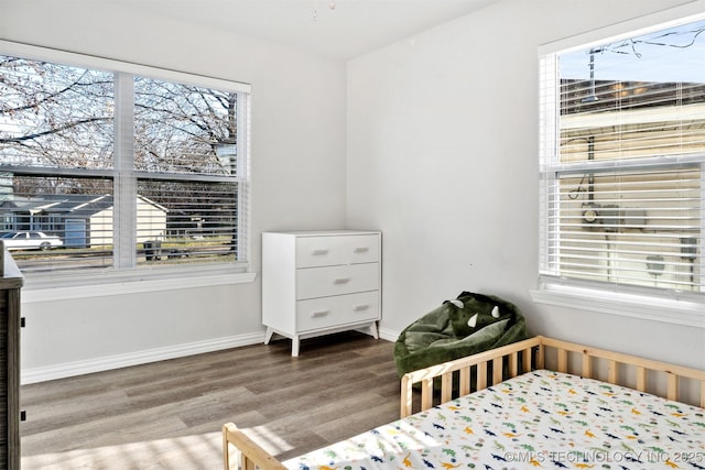 bedroom with hardwood / wood-style flooring and multiple windows