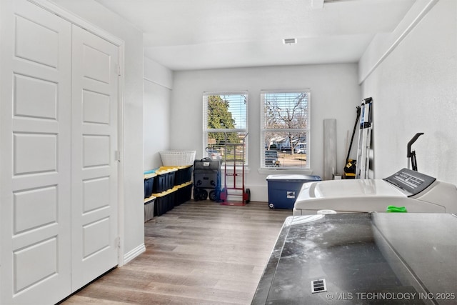 office with washing machine and clothes dryer and hardwood / wood-style floors