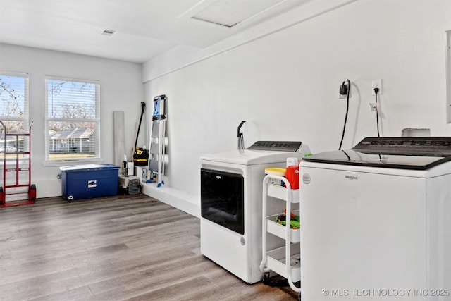 clothes washing area featuring hardwood / wood-style flooring and washer and clothes dryer