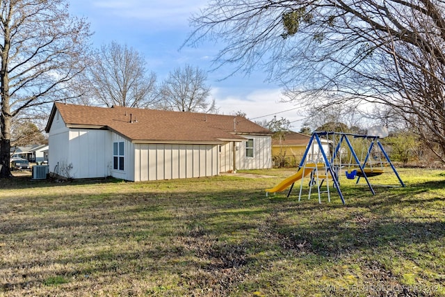 back of property with a playground, a lawn, and central AC unit