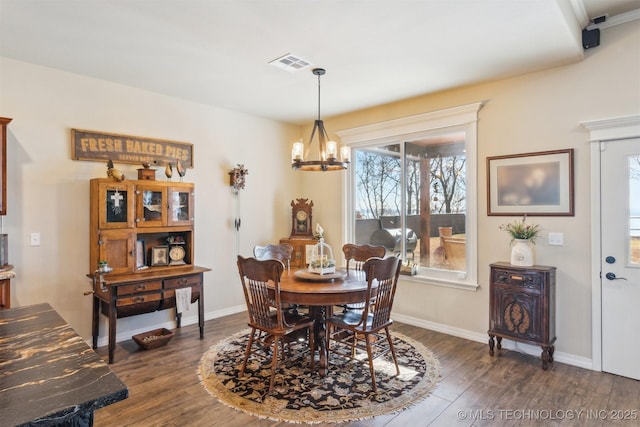 dining area featuring baseboards, dark wood-style flooring, visible vents, and a notable chandelier