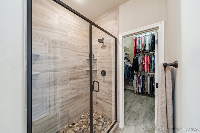 bathroom with a stall shower and a walk in closet