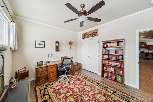 office space with crown molding, baseboards, ceiling fan, and wood finished floors