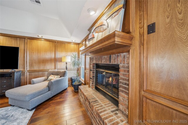 living room featuring visible vents, recessed lighting, a brick fireplace, and wood-type flooring