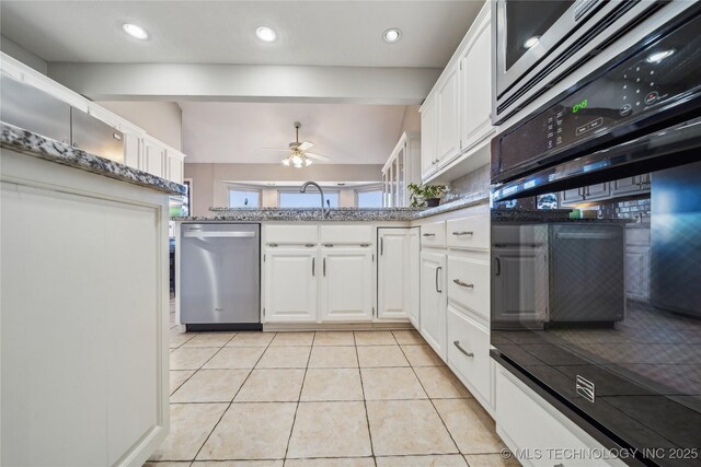 kitchen with white cabinets, appliances with stainless steel finishes, lofted ceiling, and a peninsula