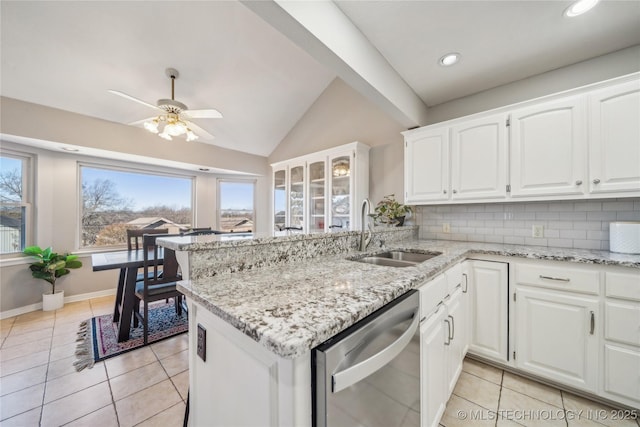 kitchen featuring a sink, white cabinetry, light tile patterned floors, decorative backsplash, and dishwasher